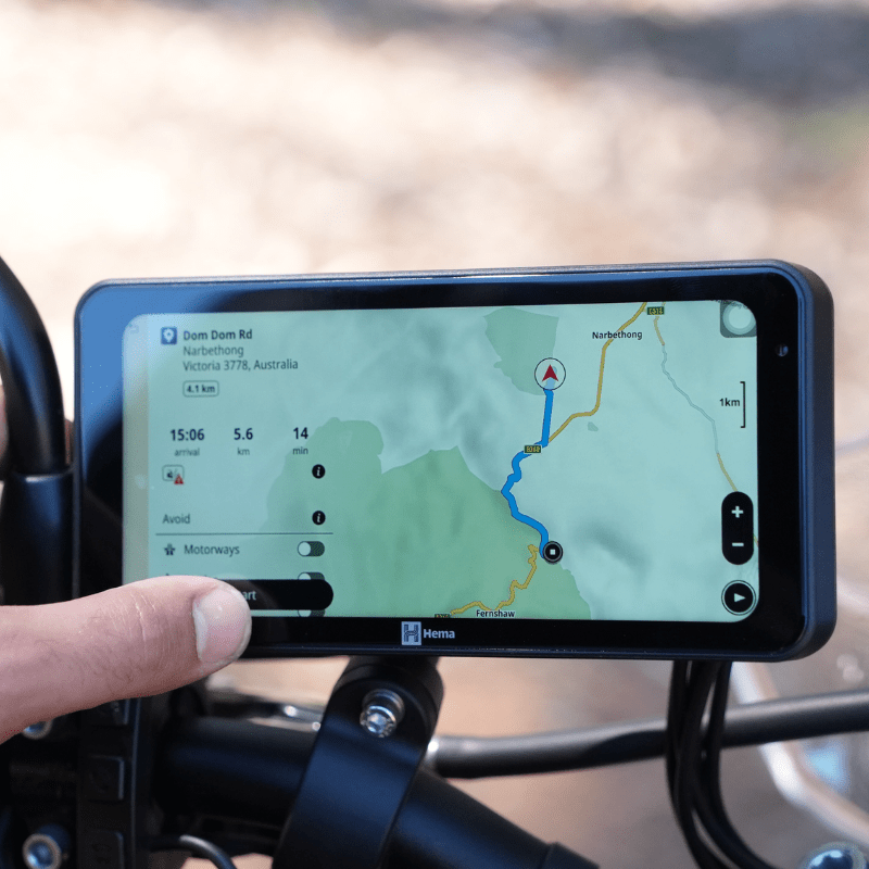 Rider using the Hema HX-M1 touch screen on motorcycle handlebars to navigate